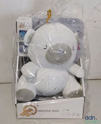 un ours en peluche blanc posé dans une boîte par terre