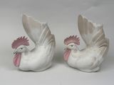 pair of white ceramic rooster figurines with pink beaks on white background