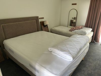 deux lits dans la chambre, recouverts de draps blancs