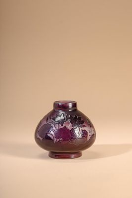 a purple vase sitting on a table with a white background