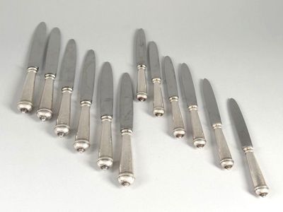 six knives are lined up in a row on a white surface