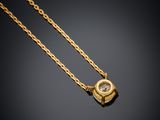 a gold plated necklace with a diamond on a black background