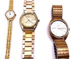 Plusieurs montres et bracelets sont posés sur une surface blanche