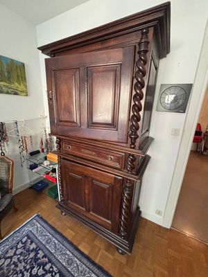 a large wooden cabinet in the corner of a living room
