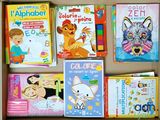 many children ' s books in a box on the table