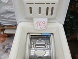 a white refrigerator with a metal lid and a silver object inside of it