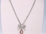 collier en argent orné de cristaux rouges et blancs, posé sur le cou d'un mannequin