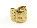 un gros plan d'une bague en or sur laquelle est gravé le visage d'une femme