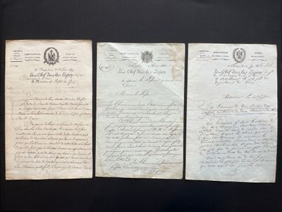 three old papers are on display in a glass case