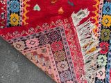 an image of a red rug with a colorful design on it
