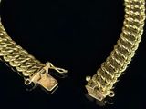 a close up of a gold chain bracelet with a lock on it