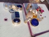 une table sur laquelle se trouvent un miroir, des flacons de parfum et d'autres objets