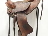 a brown saddle with a brown seat and a black handle