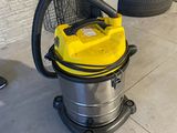 un aspirateur jaune posé par terre à côté d'un tas de pneus