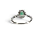 a close up of a ring with a green stone in it