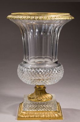 a glass vase with a gold rim on a stand