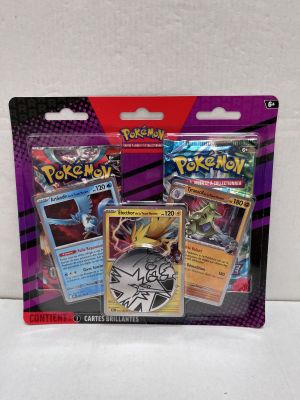a close up of two pokemon cards on a white surface