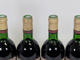 four bottles of wine are lined up on a table