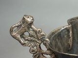 a silver cup with a spoon in it on a table