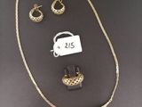 a close up of a necklace and earring on a table