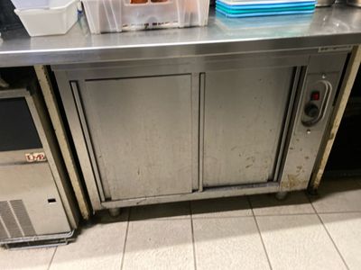 stainless steel counter top in a commercial kitchen with a refrigerator and freezer