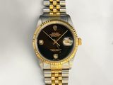 an image of a gold and silver watch with a black dial