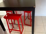 deux tabourets rouges posés près d'une table dans une cuisine