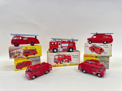several toy fire trucks are lined up in a row on a white surface