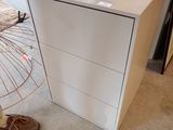 une commode blanche sur laquelle est posée une plante