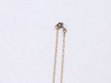 a close up of a gold necklace with a chain on a white background