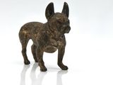 a small bronze statue of a dog on a white surface