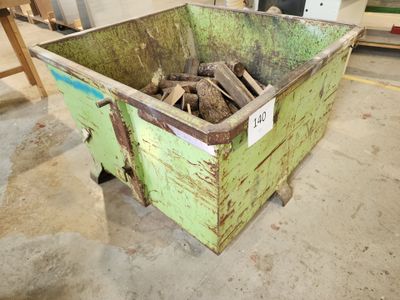 une benne verte contenant un tas de bois