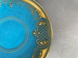 a blue and gold plate with a gold border on it