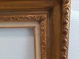 an image of a picture of a gold frame on a white wall