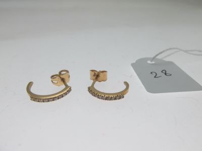 deux paires de boucles d'oreilles en or ornées de pierres noires sur un fond blanc