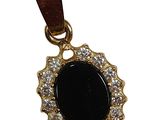 un gros plan d'un pendentif orné d'une pierre noire entourée de diamants blancs