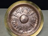 a metal plate that has a sun design on it