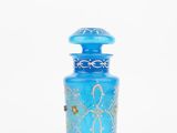 blue glass vase with a gold design on the top