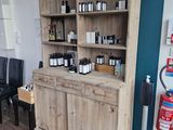 une armoire en bois sur laquelle sont posées des bouteilles, dans une pièce