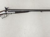 un fusil accroché au mur, muni d'une crosse en bois