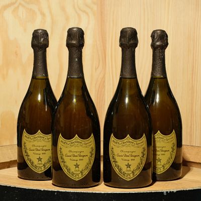 three bottles of champagne sitting on top of a wooden barrel
