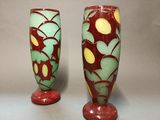 pair of red and green vases sitting on top of a table