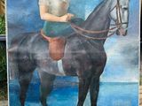 un tableau représentant une femme à cheval sur la plage