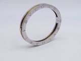 a close up of a silver and gold ring on a white surface