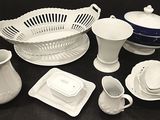 a lot of white dishes and cups on a black table