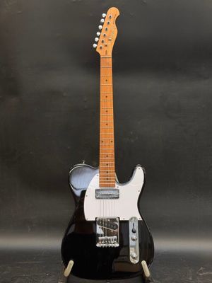 une guitare électrique noire et blanche posée sur une table