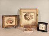 trois photos encadrées et une horloge sont posées sur une table à côté d'une horloge
