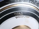 a close up of a decorative vase with a gold rim