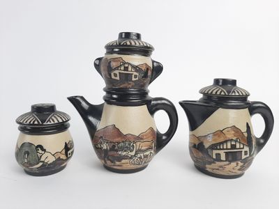 three pieces of pottery that are sitting on a table