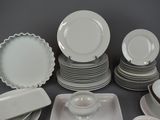 a lot of white plates and bowls on the table